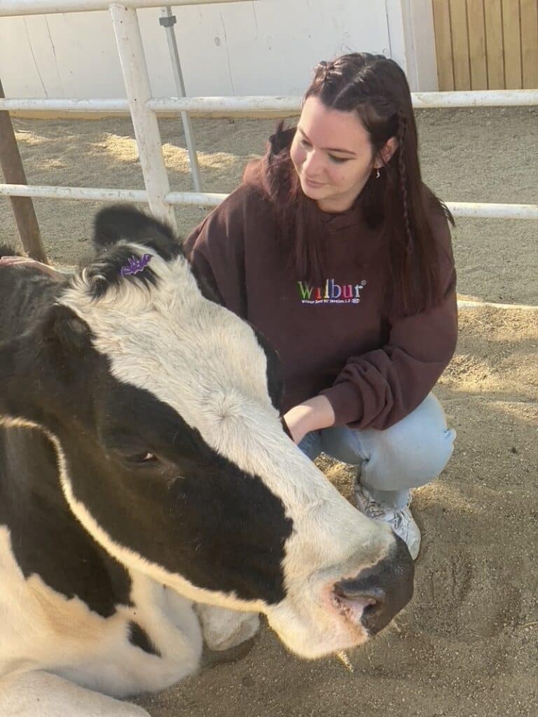 Anya from WhereGalsWander hugs a cow at Gentle Barn